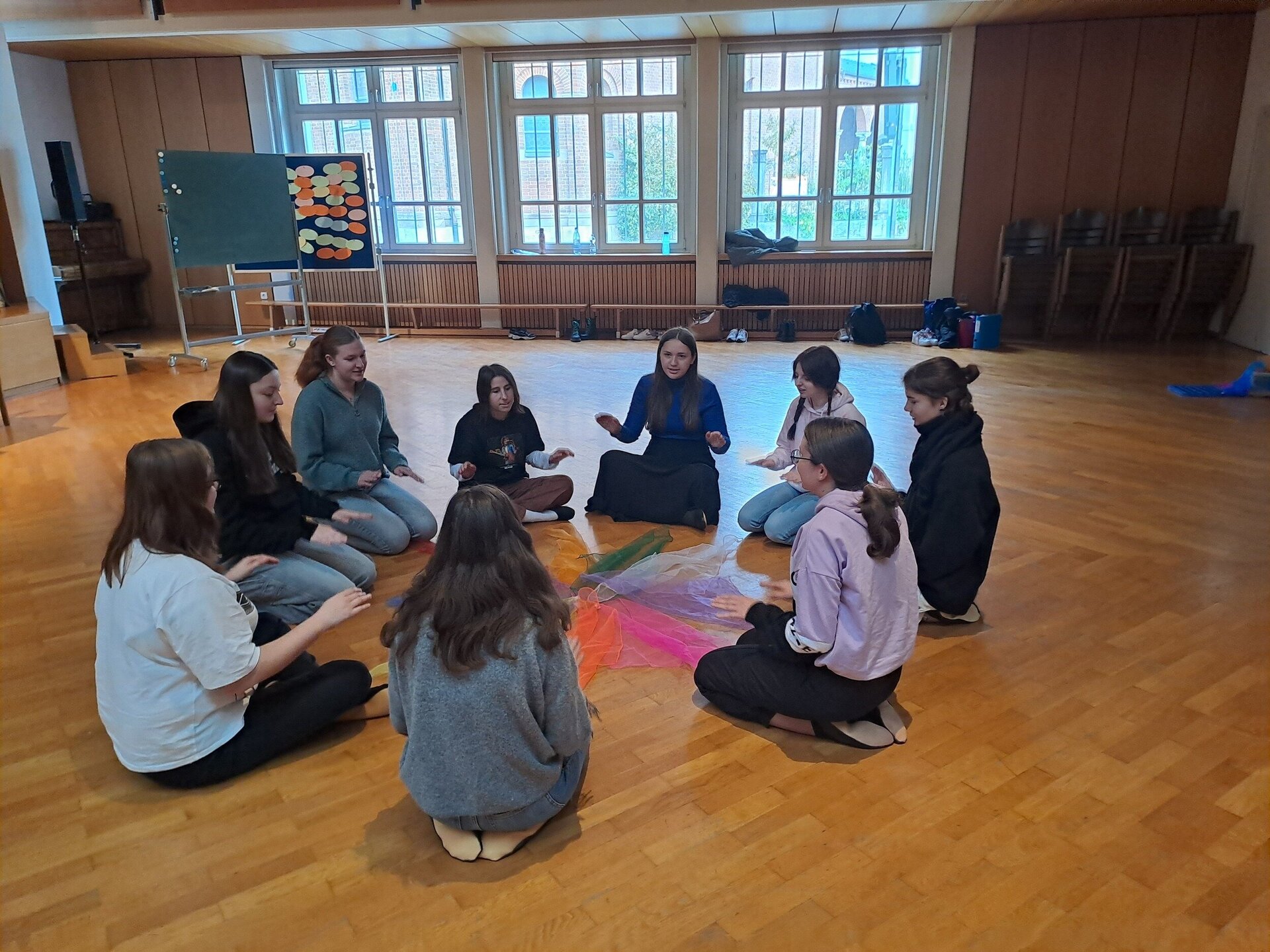 Studierende im Kreis mit Tüchern